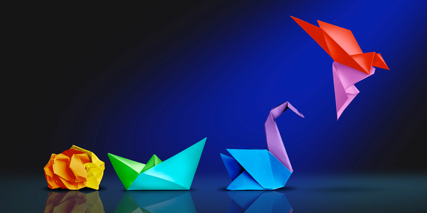 a crumbled craft paper next to origami of boat, swan, and a bird