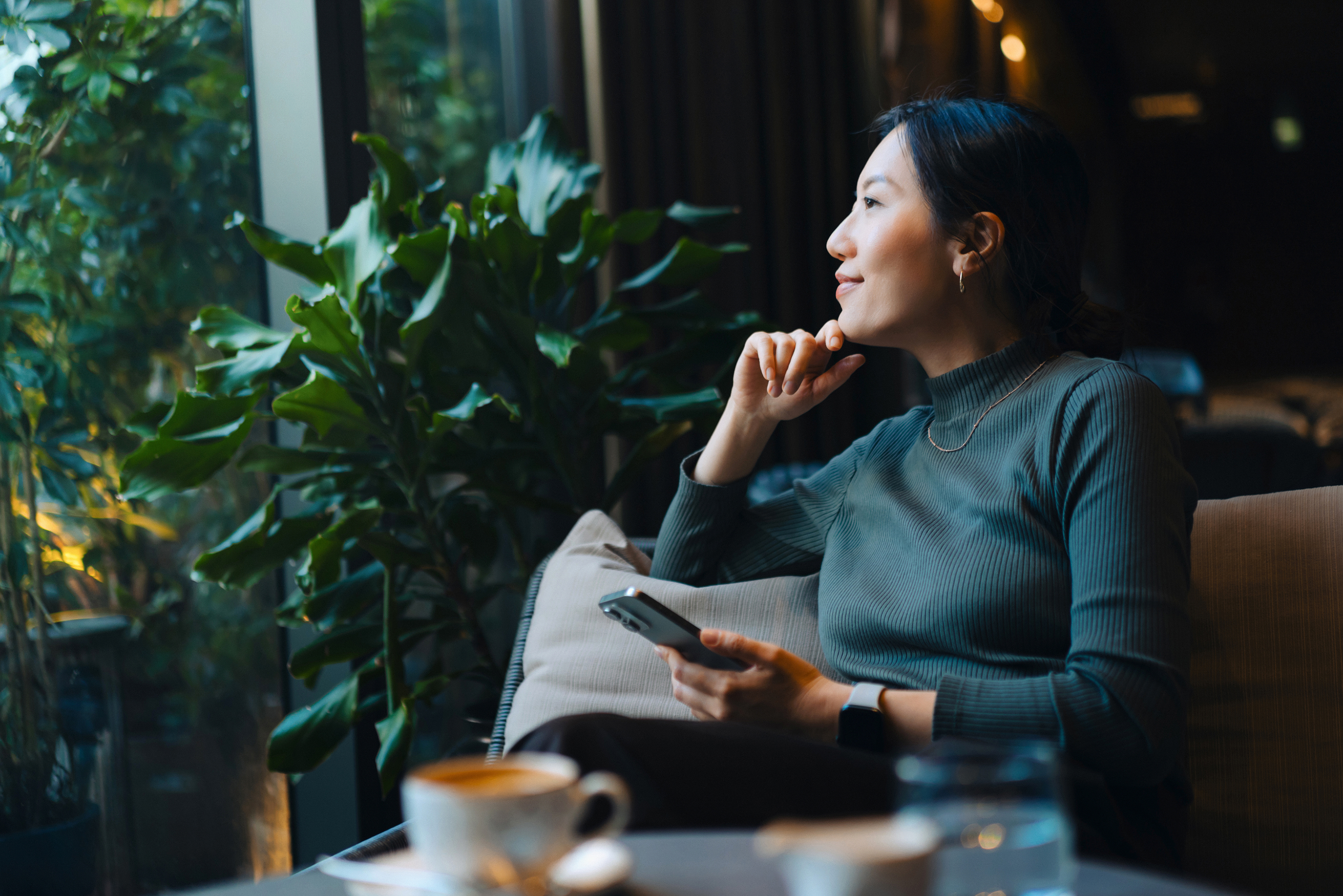 Woman smiling while reviewing financial planning by window 