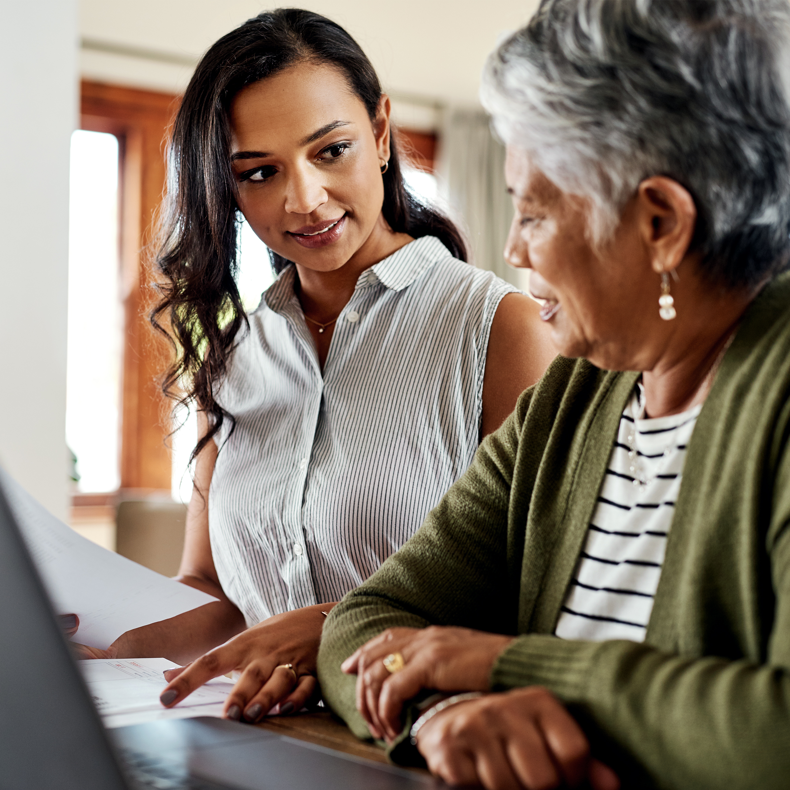 A young woman helps her grandmother with RMDs and taxes in their home. 
