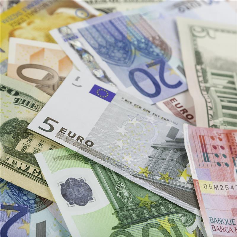 Stack of different currencies representing wealth management in global economy