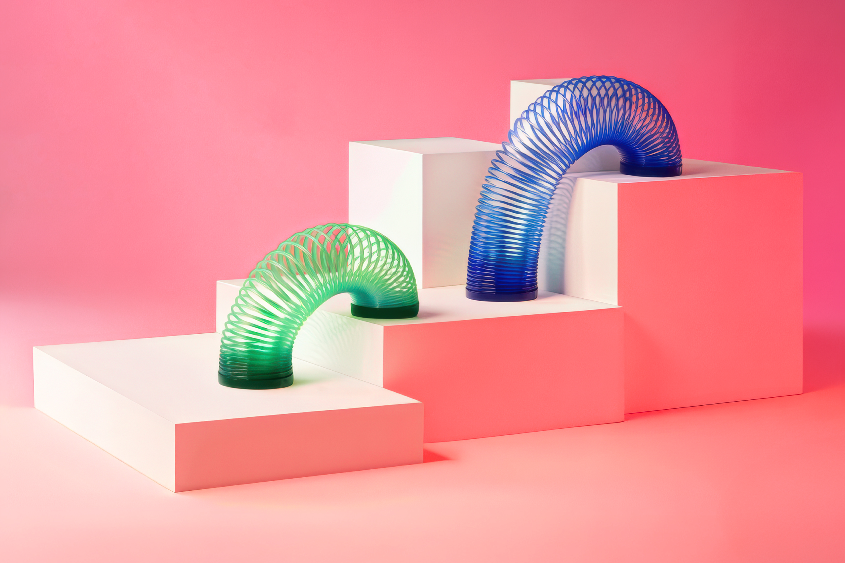 Slinky toys climbing the steps of a bar chart represent the flexible thinking health care and higher ed employers are using in order to grow.