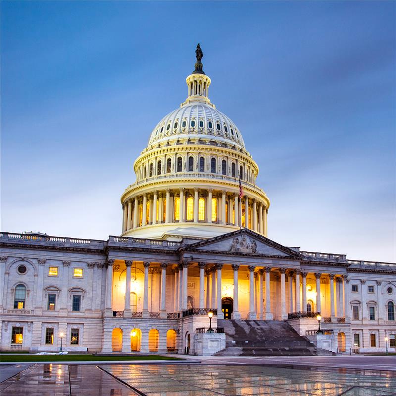 The U.S. Capitol building illuminated at dusk, showcasing its architectural grandeur against a twilight sky.