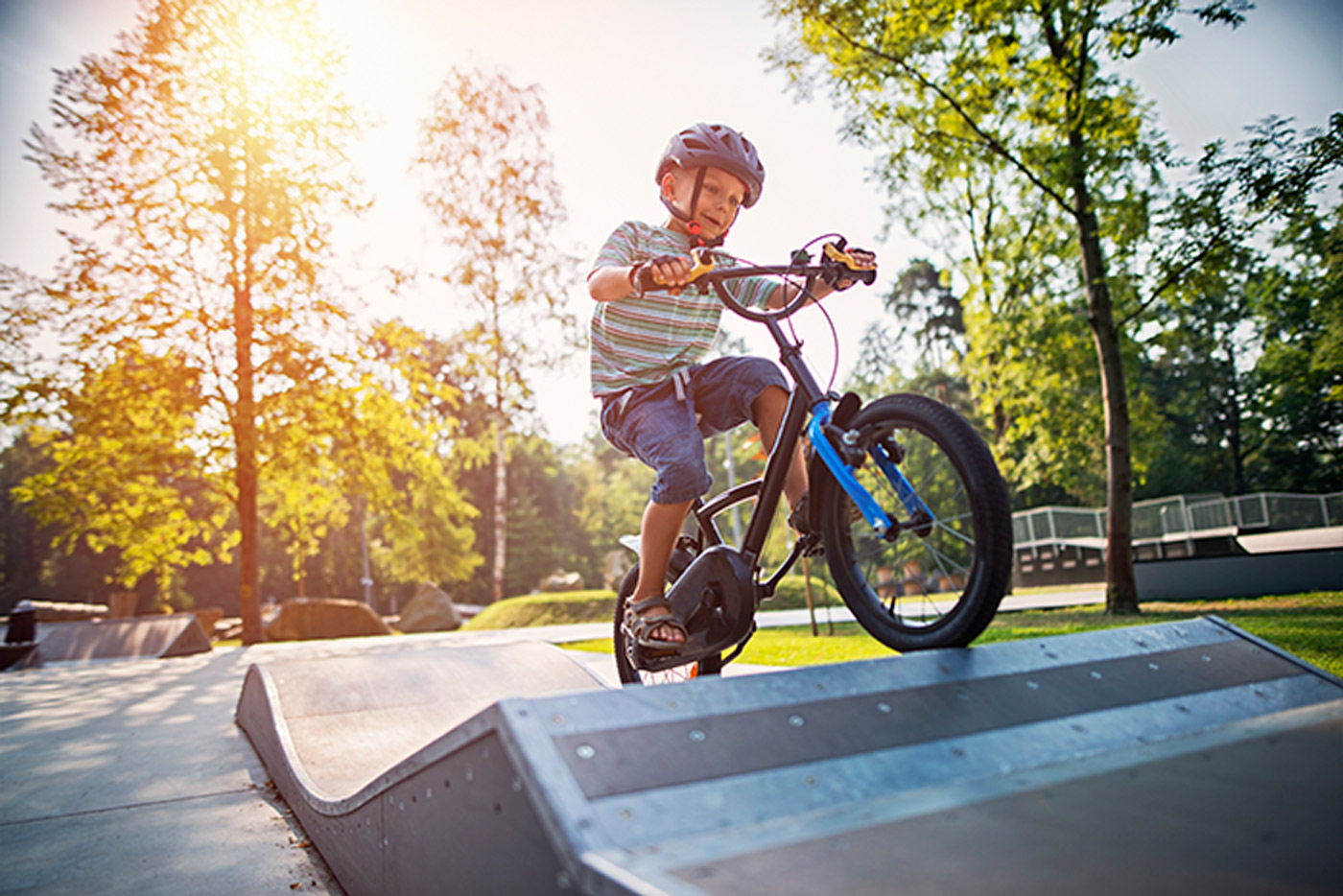 A child rides his bike over a ramp.