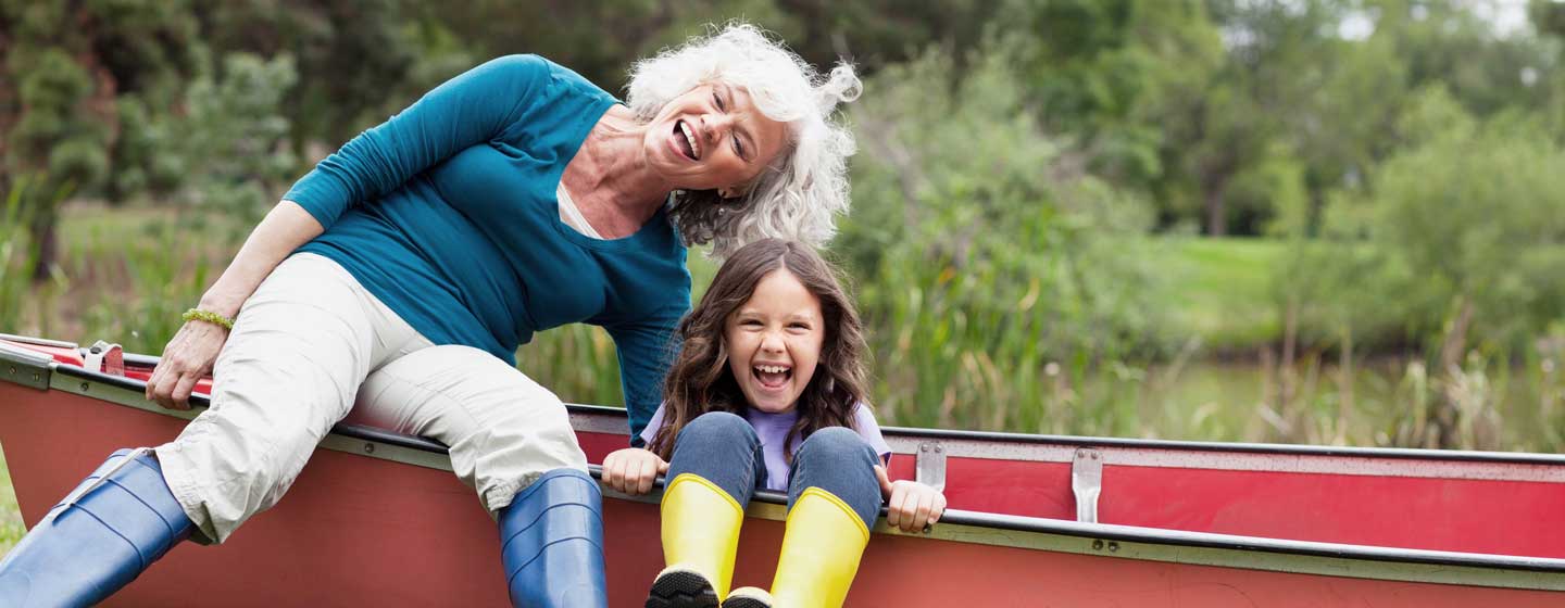 Woman and a girl smiling while sitting on a canoe